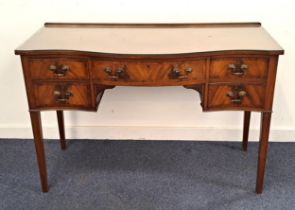 MAHOGANY SERPENTINE KNEEHOLE DESK with a raised back above an arrangement of five crossbanded