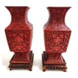 PAIR OF CHINESE CINNIBAR VASES with decorative floral decoration on square hardwood stands, 23cm