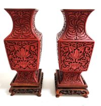 PAIR OF CHINESE CINNIBAR VASES with decorative floral decoration on square hardwood stands, 23cm