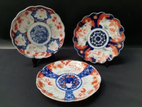 THREE JAPANESE IMARI BOWLS each with a wavy rim and decorated in iron red and blue, each 21cm
