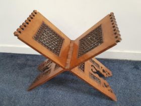 ISLAMIC QURAN STAND of folding X frame design with carved pierced and turned panels, 54cm x 46cm