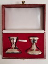 PAIR OF ELIZABETH II SILVER CANDLESTICKS of stout form raised on circular loaded bases, in a