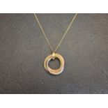NINE CARAT THREE TONE GOLD PENDANT in the form of an entwined Russian wedding ring, the white gold