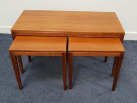 TEAK NEST OF OCCASIONAL TABLES with a rectangular top and standing on tapering supports, with two