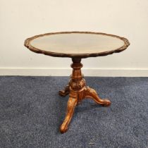 WALNUT OCCASIONAL TABLE with a circular pie crust top, standing on a turned column and tripod