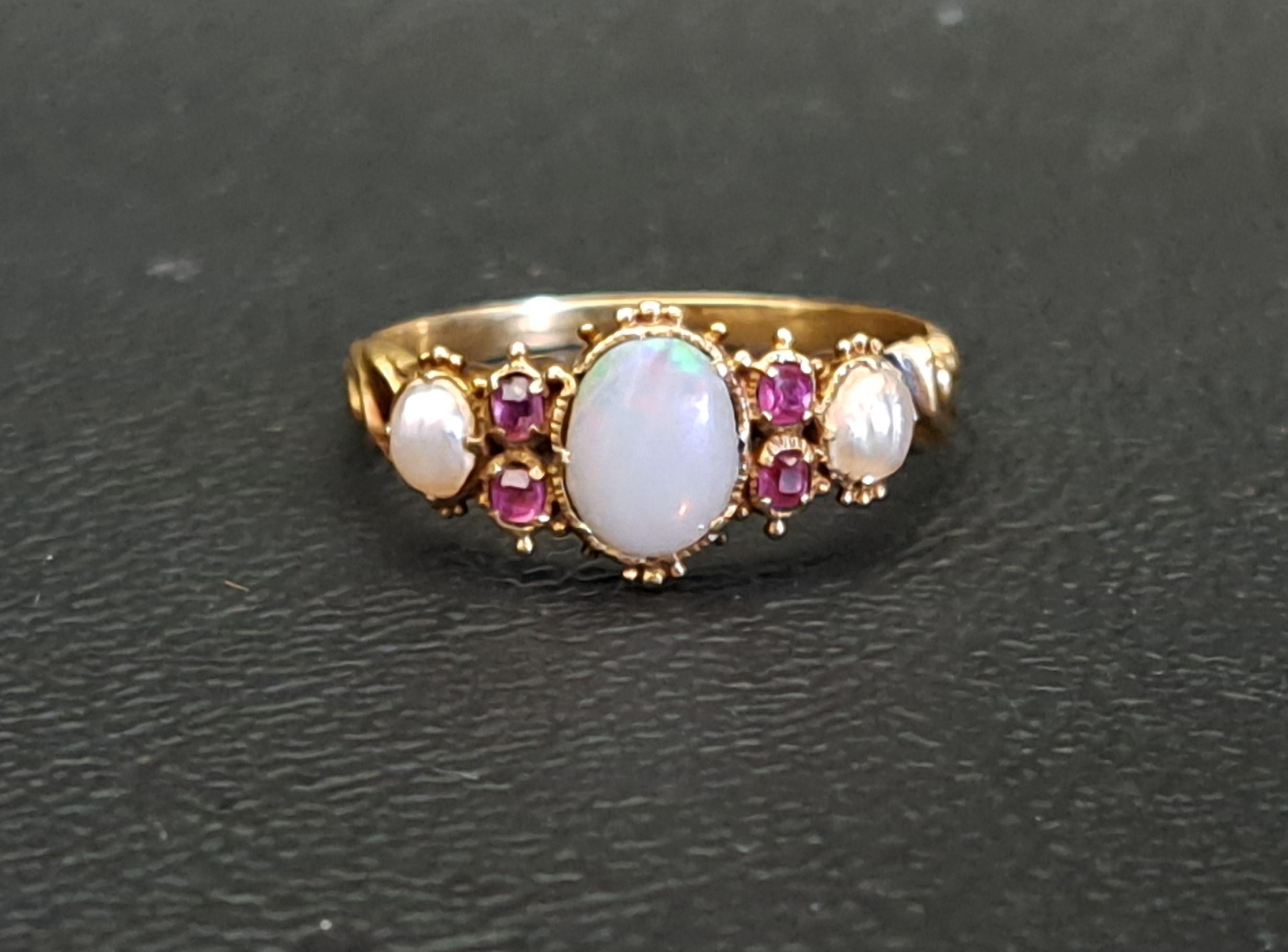 VICTORIAN OPAL, RUBY AND SEED PEARL RING the central opal measuring 6mm x 5mm, in unmarked high