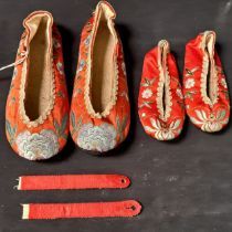 PAIR OF CHINESE RED SILK SLIPPERS decorated with floral motifs, together with a pair of children's