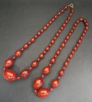 TWO AMBER BEAD NECKLACES believed to have originally been one larger necklace, the largest bead