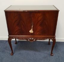 MAHOGANY DRINKS CABINET with a pair of doors opening to reveal a mirrored back, shelf, drawer and