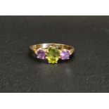 PERIDOT AND AMETHYST THREE STONE RING the central oval cut peridot approximately 0.75cts flanked
