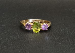 PERIDOT AND AMETHYST THREE STONE RING the central oval cut peridot approximately 0.75cts flanked