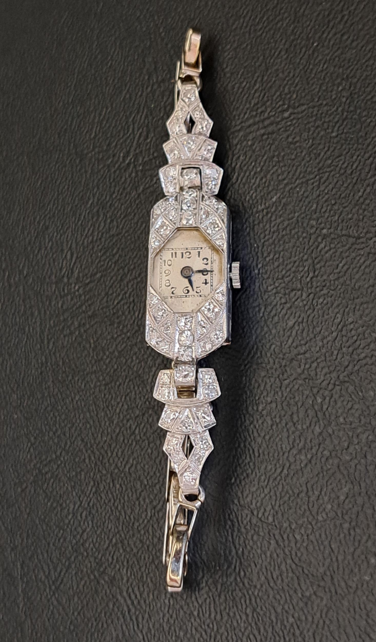 DIAMOND SET PLATINUM CASED COCKTAIL WATCH on nine carat white gold strap with further diamonds, in