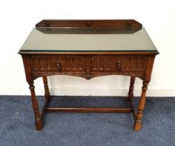 OAK SIDE TABLE with a shaped raised back above two carved frieze drawers, standing on turned