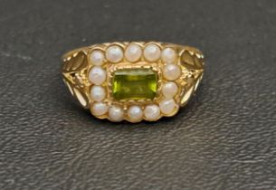 PERIDOT AND PEARL CLUSTER RING the central horizontally set rectangular cut peridot in a fourteen