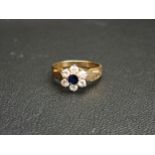 SAPPHIRE AND CZ CLUSTER RING the central round cut sapphire in six CZ surround, on nine carat gold