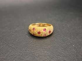 RUBY SET BOMBE STYLE GYPSY RING with seven flush set rubies against a textured setting and shank, in