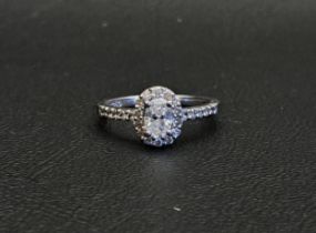 DIAMOND CLUSTER RING the central oval cut diamond approximately 0.45cts in diamond surround and with