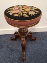 VICTORIAN ROSEWOOD ADJUSTABLE PIANO STOOL with a circular needlework seat decorated with flowers, on
