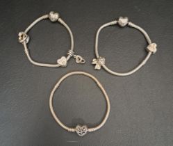 THREE PANDORA SILVER MOMENTS SNAKE CHANE CHARM BRACELETS all with heart clasps, with five various