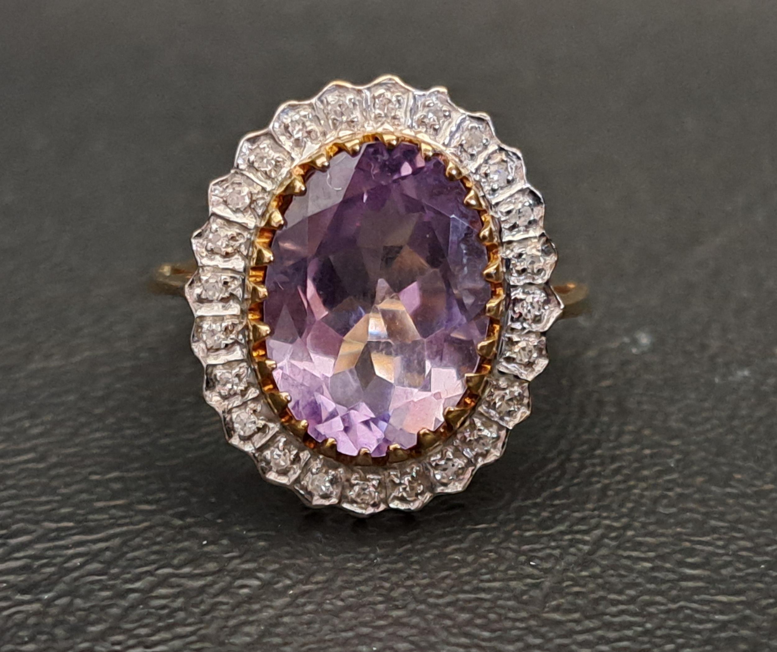 AMETHYST AND DIAMOND CLUSTER RING the central oval cut amethyst measuring approximately 14.1mm x