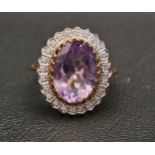 AMETHYST AND DIAMOND CLUSTER RING the central oval cut amethyst measuring approximately 14.1mm x