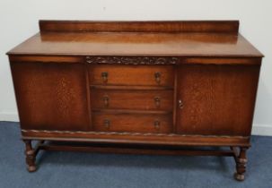 1950s OAK SIDEBOARD with a raised back above a rectangular top with three central drawers flanked by