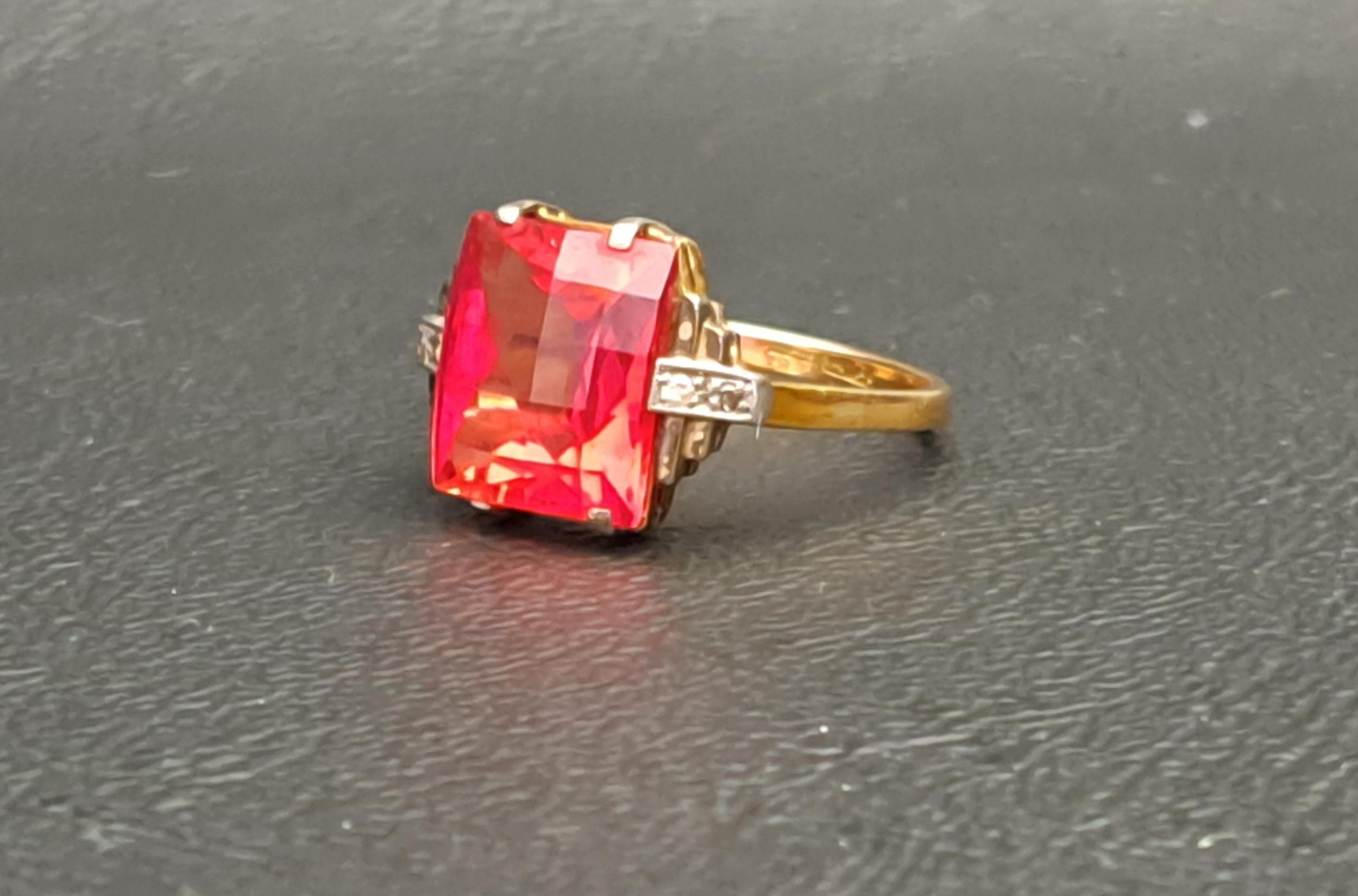 RED GEM AND DIAMOND SET RING the central checkerboard cut gemstone possibly ruby and measuring
