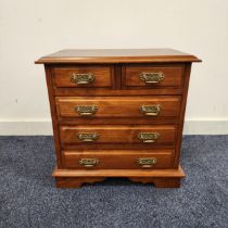 SMALL TEAK CHEST OD DRAWERS with a moulded top above two short panelled drawers and three long