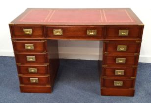 MAHOGANY KNEEHOLE DESK the red leather top with inset brass corners and banding, with an arrangement