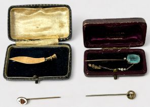 A 9ct gold brooch modelled as a Kukri knife with sheath, together with a 9ct gold pin, set with a
