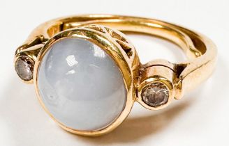 An 18ct yellow gold dress ring, set with a round shaped grey star sapphire, bezel set with a round