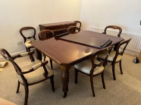 A large Victorian mahogany dining table, two leaves, canted corners, raised on four turned
