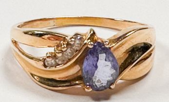 A 14ct yellow gold dress ring, set with an oval shaped tanzanite to the centre, with four small