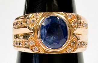 A 14ct yellow gold dress ring, bezel set to the centre with an oval shaped sapphire, and twenty-four