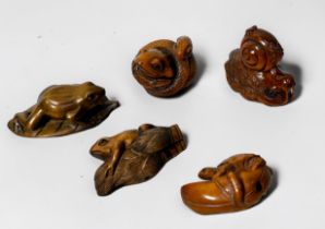 Five various Japanese carved and stained boxwood netsuke, frog on leaf, frog with coiled snake,