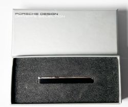 A Porsche design clutch tie-pin, with discreet Porsche logo, made of black anodised aluminium and
