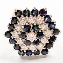 An 18ct white gold dress ring, claw-set with 24 x round-shaped dark blue sapphires, and 13 x round