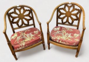 A pair of early 20th Century low mahogany tub chairs, pierced flower back, red floral upholstered