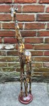A model of a giraffe by ‘Collage’, with printed safari decoration, raised on naturalistic base,