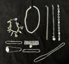 A collection of assorted silver bracelets and necklaces, including a gate bracelet with heart