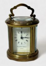 A Swiss made miniature brass carriage clock, with oval case, white enamel dial with Roman numerals
