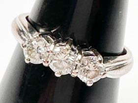 An 18ct white gold ring, claw set with three round brilliant cut diamonds in an open-backed gallery,