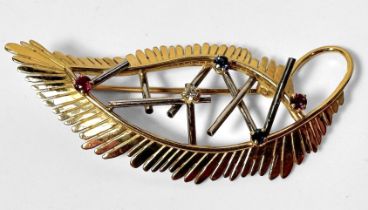 An 18ct gold brooch of stylised leaf design, claw-set with 2x rubies, 2x sapphires and a diamond,