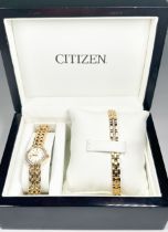 A gold plated wristwatch by Citizen, with oval shaped face and white faceted stones set to the