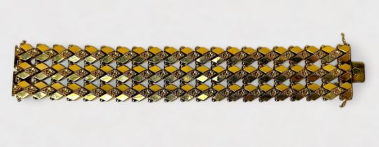 An 18ct Gold bracelet of articulated lozenge design, with sliding lock and safety clips, 3cm wide