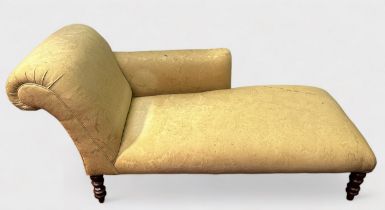 A Victorian-style chaise longue, with cream foliate upholstery and matching bolster cushion, on