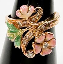 An 18ct yellow gold dress ring in a foliate style, set with small diamonds in pink and green