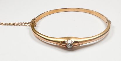 A 9ct yellow gold hinged bangle, eight-claw set with a round-shaped old cut diamond to the centre,