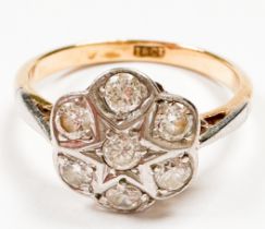 An 18ct yellow gold cluster ring, set with seven round diamonds in a white gold star and daisy