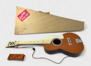 A vintage Elvis Presley toy guitar by Selcol, the brown, cream and burgundy plastic four string